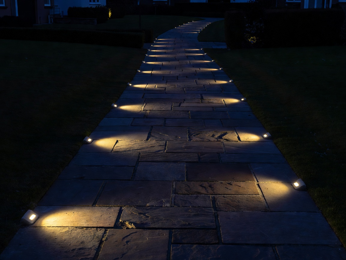 Stone residential pathway clearly illuminated by staggered low-level lighting